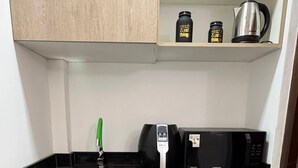 A compact kitchen with a sink, a coffee maker, a microwave, and a refrigerator. - Moonlight Iguazu Apart (Puerto Iguazú)