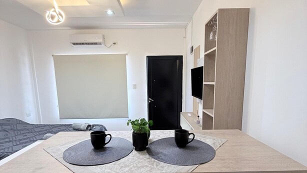A modern room with a desk, two chairs, a television, and a plant. - Moonlight Iguazu Apart (Puerto Iguazú)