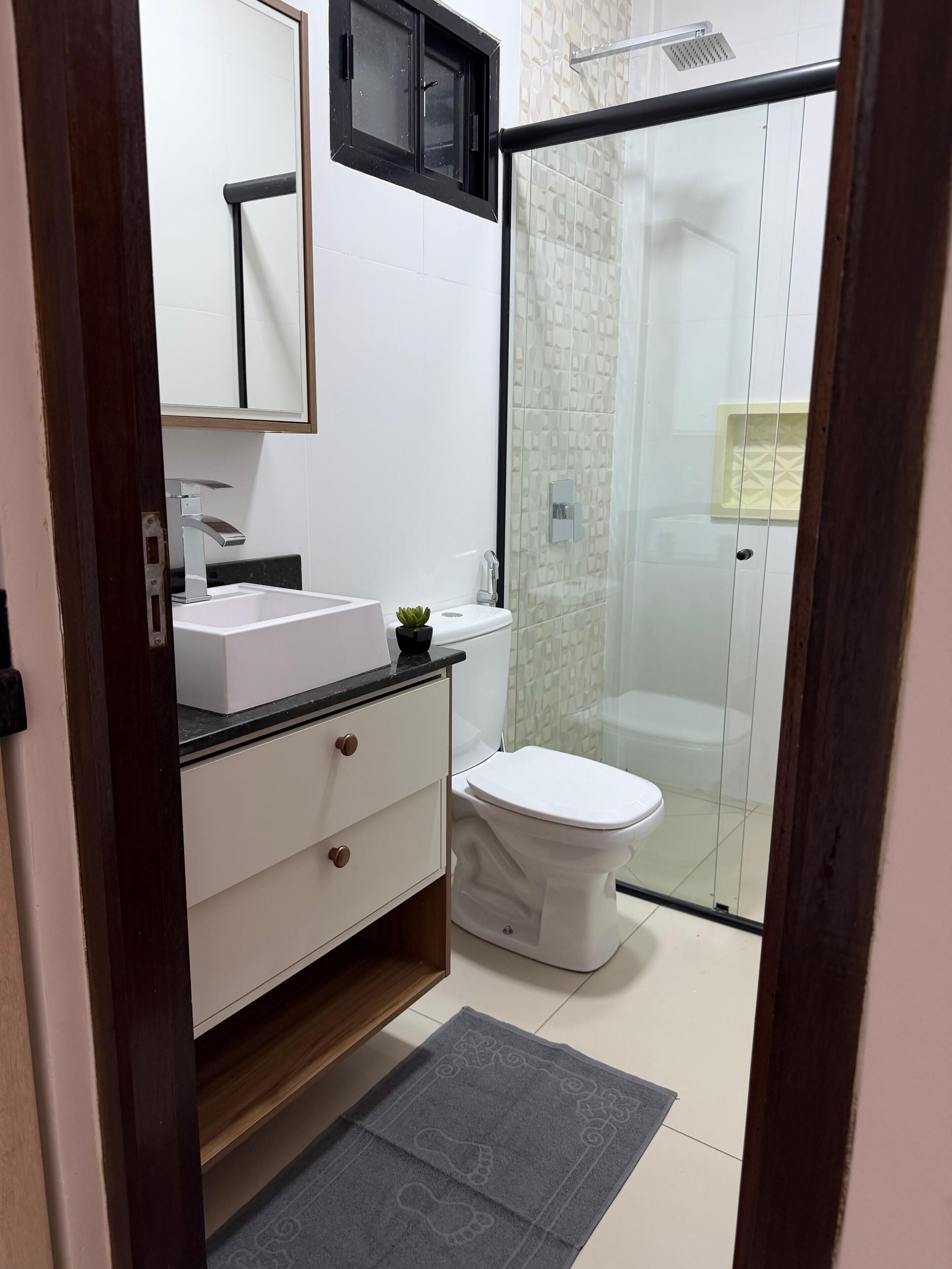 Chuveiro, secador de cabelo, toalhas de banho, papel higiênico