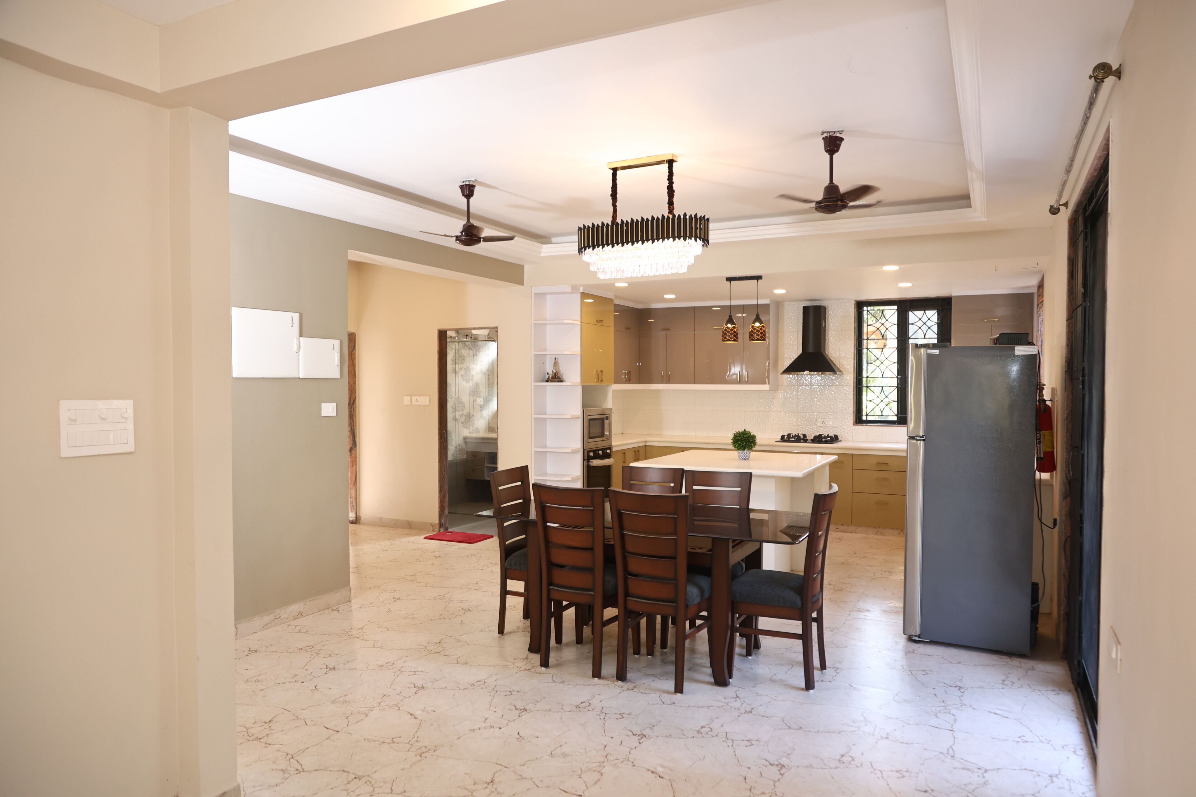 Cocina moderna con comedor, suelo de mármol y ventiladores de techo.