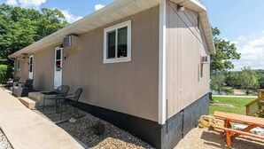 A single-story building with a covered patio area, outdoor seating, and a view of a lake. - Skyline Cabin - Lakefront Table Rock Lake (Galena)