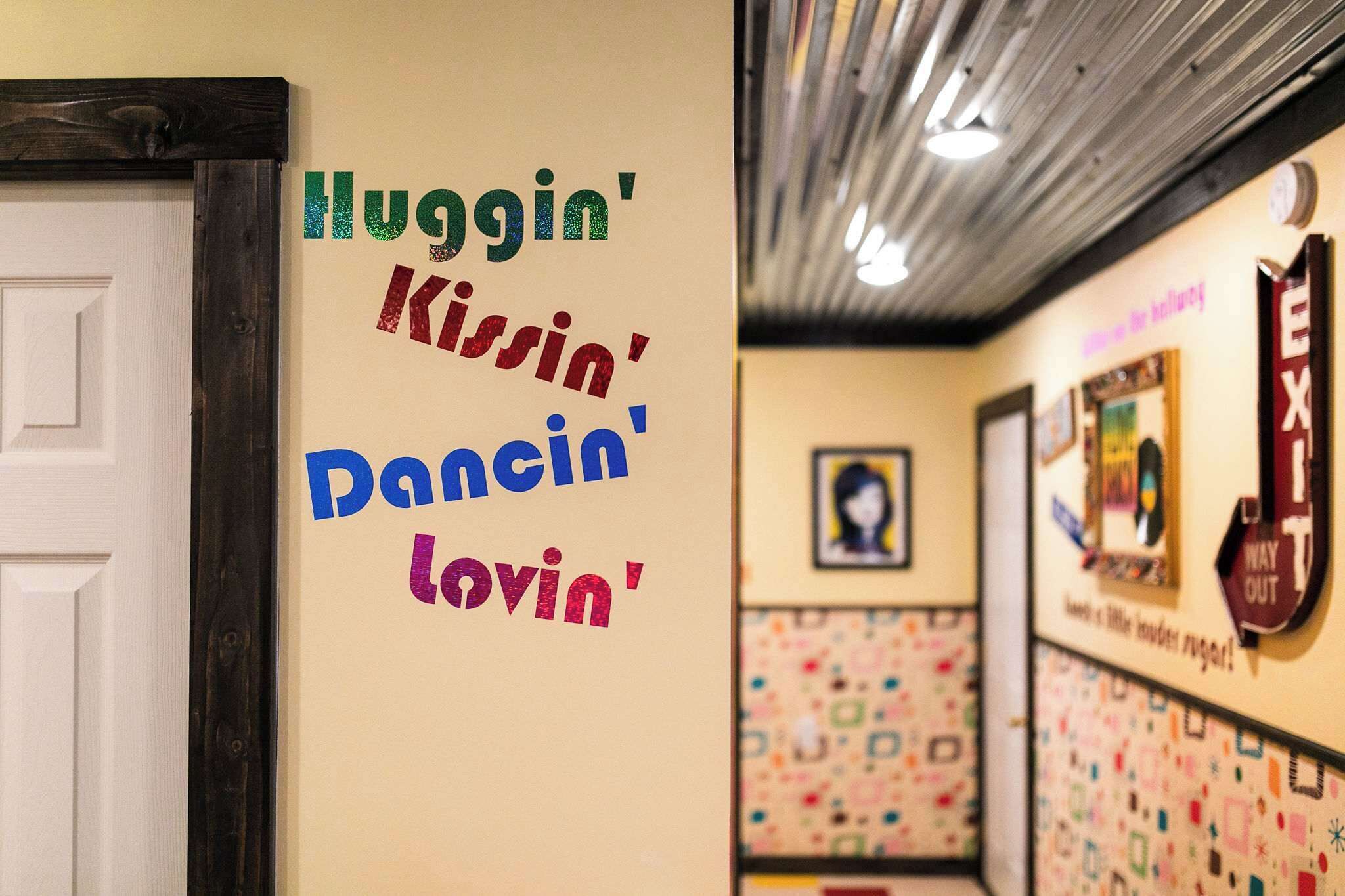 A wall with colorful text and a patterned wall in the background.