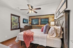 A bedroom with a bed, a ceiling fan, a TV, and a window with blinds. - Lakefront 4BR · Pool · Resort Dock · Sleeps 12 (Galena)