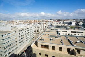 A high-rise building with multiple floors, a parking area, and a clear view of the cityscape in the background. - Casa Marmite Sea View (Matosinhos)