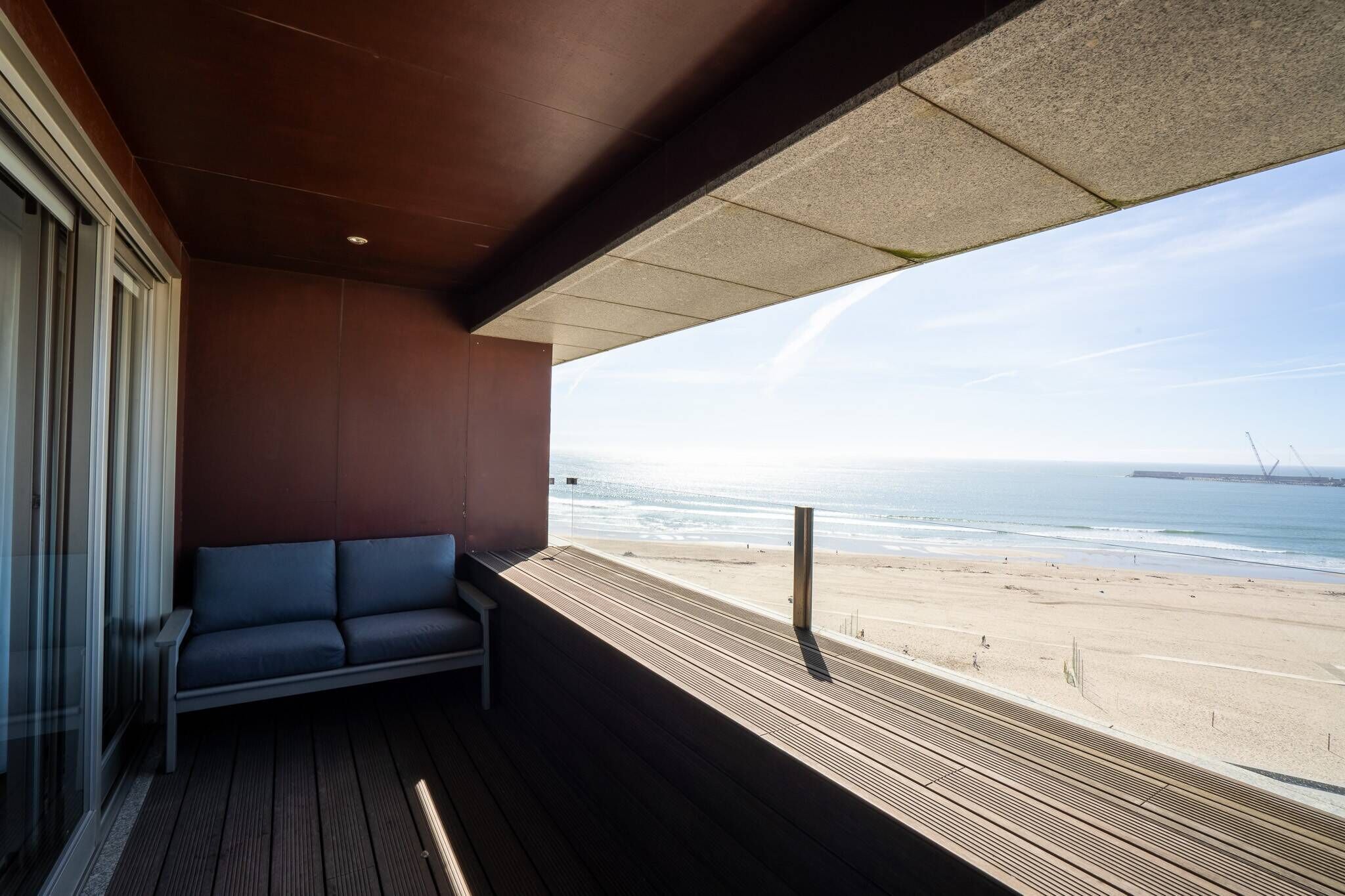 A balcony with a view of the beach and ocean.
