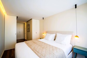 A hotel room with a bed, bedside tables, a wardrobe, and a wall-mounted light fixture. - Casa Marmite Sea View (Matosinhos)