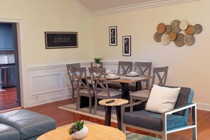 A dining area with a table and chairs, a sofa, and a wall with decorative plates. - Mint Hill Luxury Retreat / Near Charlotte/4BR/3BA (Mint Hill)