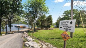 A sign indicating directions to Hideaway Marina and Hideaway Resort Dock with a caution sign for a kid zone.