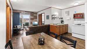 Une cuisine équipée d’un four à micro-ondes, d’une cuisinière et d’un coin repas avec une table et des chaises.