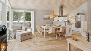Ein modernes Wohnzimmer mit Kamin, Essbereich und Küche.