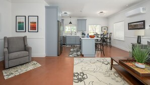 A modern kitchen with grey cabinets, a central island, and a dining area with a table and chairs. - Wonderful 2-bedroom house with Zonal Mini Splits , tree lined nieghborhood (Phoenix)