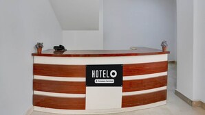 A hotel reception desk with a sign indicating it is company-serviced.