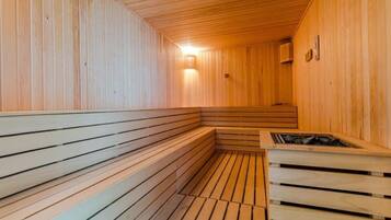 A sauna with wooden benches and a central heating element.