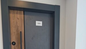 Eine Tür mit Nummernschild, Holzverkleidung und Metallrahmen.