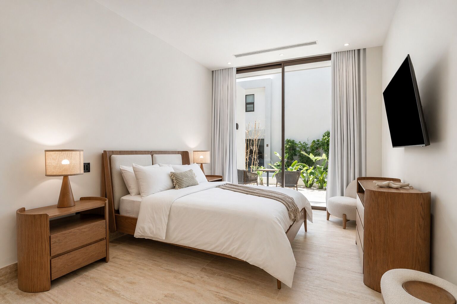 Une chambre d’hôtel moderne équipée d’un lit, de tables de chevet, d’une télévision et d’un balcon agrémenté de plantes.