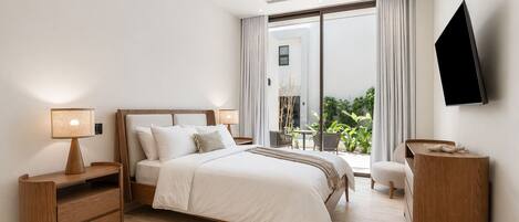 Une chambre d’hôtel moderne équipée d’un lit, de tables de chevet, d’une télévision et d’un balcon agrémenté de plantes.
