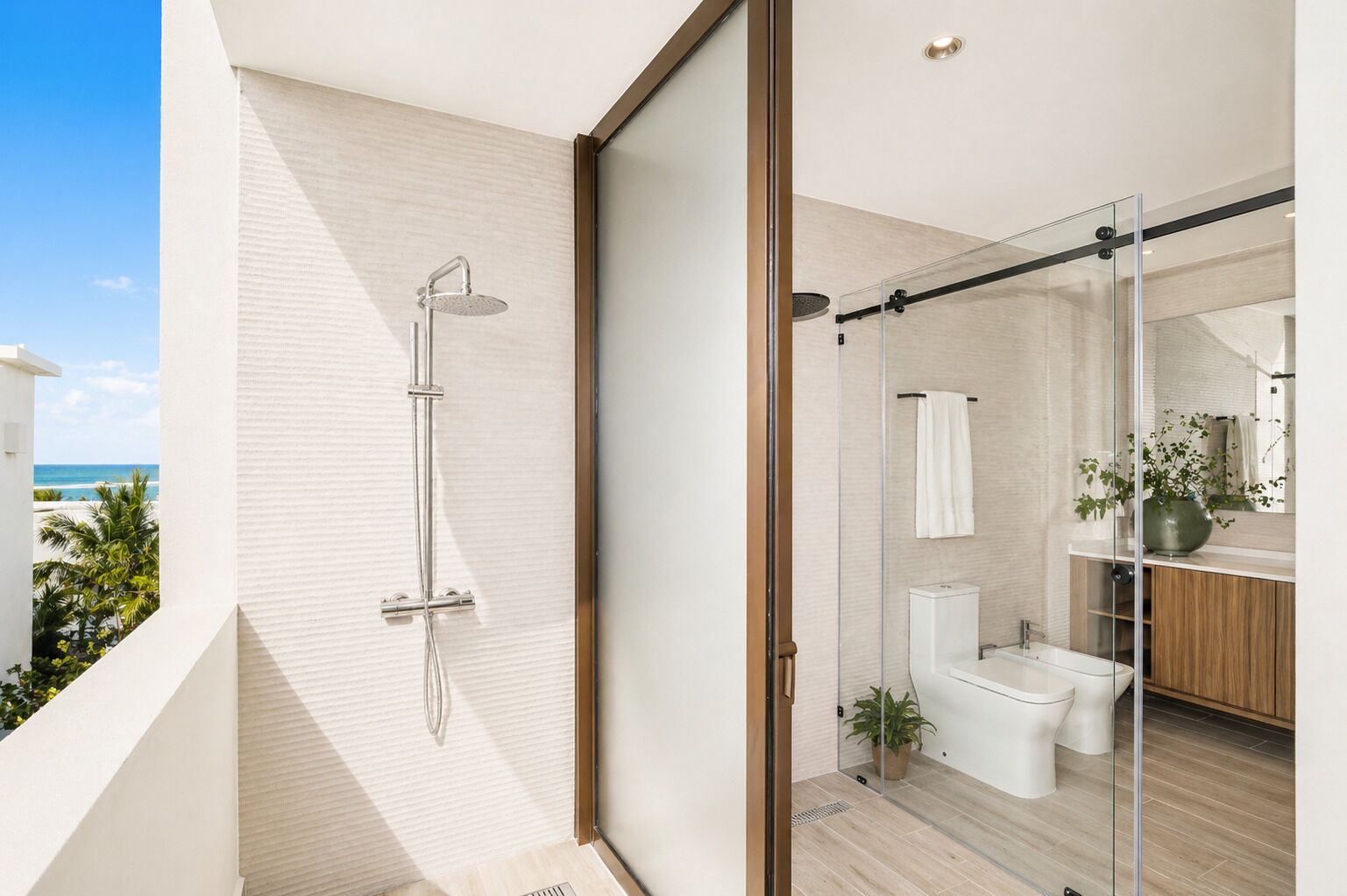 A modern bathroom with a glass shower enclosure, a toilet, and a sink.