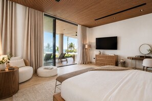 A modern bedroom with a large bed, a TV, and a view of the ocean. - Eden Cabarete  (Cabarete)