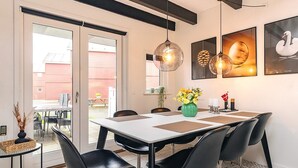 A dining area with a table, chairs, and pendant lights. - 8 Person Holiday Home in Hadsund (Hadsund)
