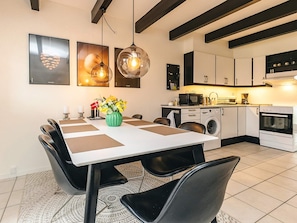 A modern kitchen with white cabinets, a microwave, a washing machine, and an oven. - 8 Person Holiday Home in Hadsund (Hadsund)