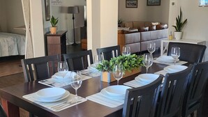 A dining room with a dark wooden table set for six, surrounded by chairs. - Rexford Sound HideAway-Pool and Pet Friendly (Navarre)