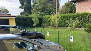 Een parkeerplaats met een auto en een gebouw op de achtergrond.
