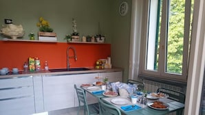 Een keuken met een spoelbak, aanrecht en eettafel, gedekt voor een maaltijd.