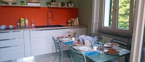A kitchen with a sink, countertop, and dining table set for a meal.