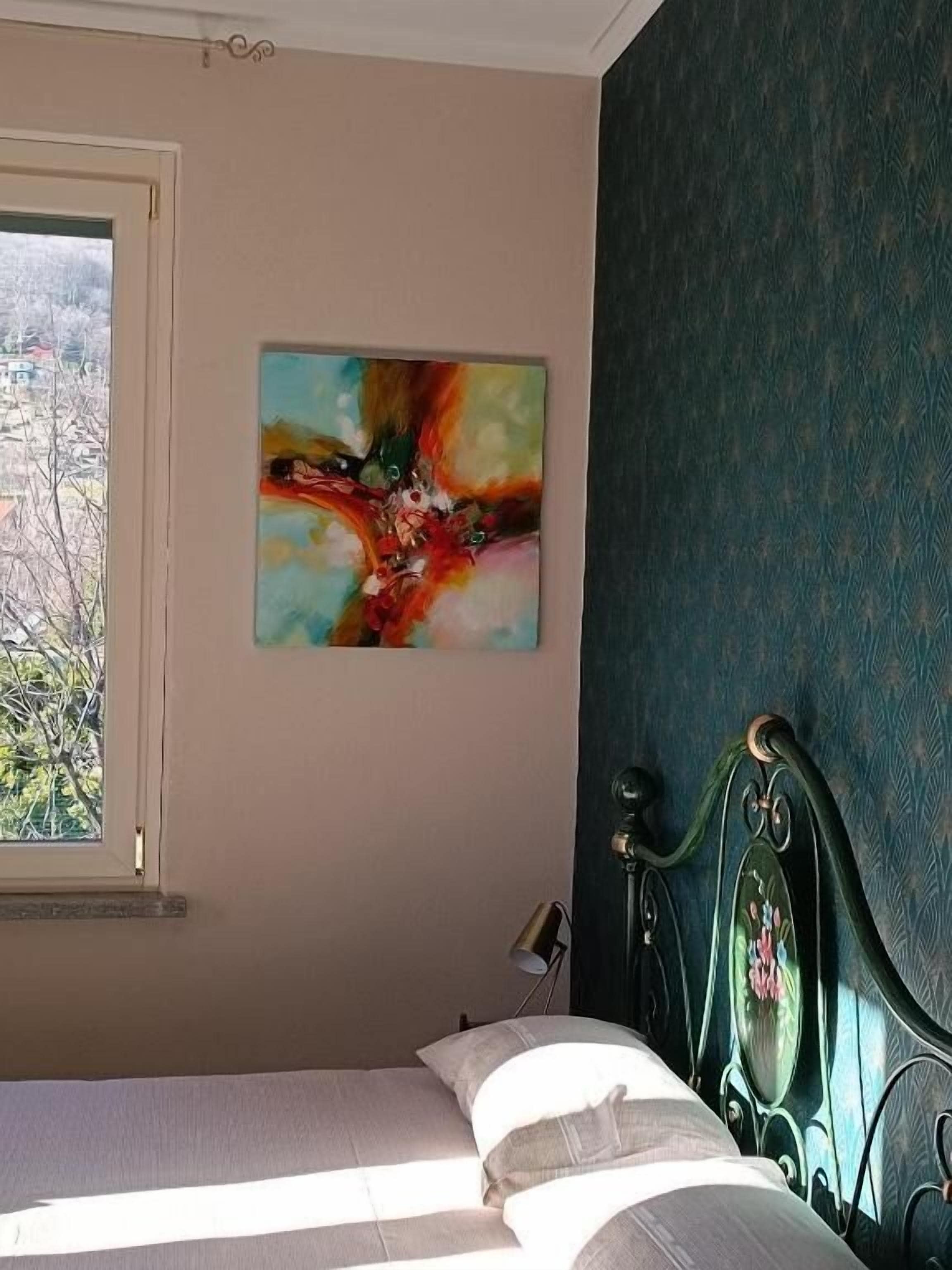 Una camera da letto con un letto, una finestra, un quadro e una parete scura con motivo.