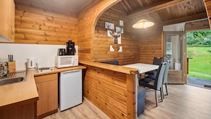 A wooden cabin interior with a kitchen, dining area, and a door leading to a garden. - Blockhaus im Harz fur Familien (Oberharz am Brocken)