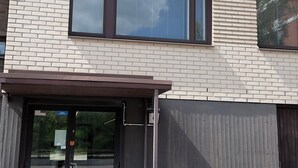 A multi-story building with a brick facade, large windows, and a covered entrance. - Modern Apartment in Myyrmäki – Direct Train to Helsinki & Airport (Vantaa)