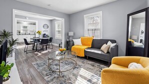 A modern living room with a sofa, coffee table, and dining area. - Cozy Getaway Near Downtown Concord (Concord)