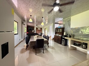 Una cocina amplia con comedor, ventilador de techo y salpicadero de mármol.