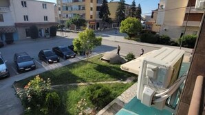 A residential area with a swimming pool, parked cars, and multi-story buildings. - Te bunkeri (Ersekë)