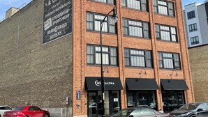 Un edificio de ladrillo de varios pisos con un gran letrero en el costado que anuncia Smith, Follett & Crowl.