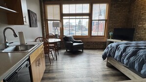 Habitación compacta con cocina, comedor y una cama.