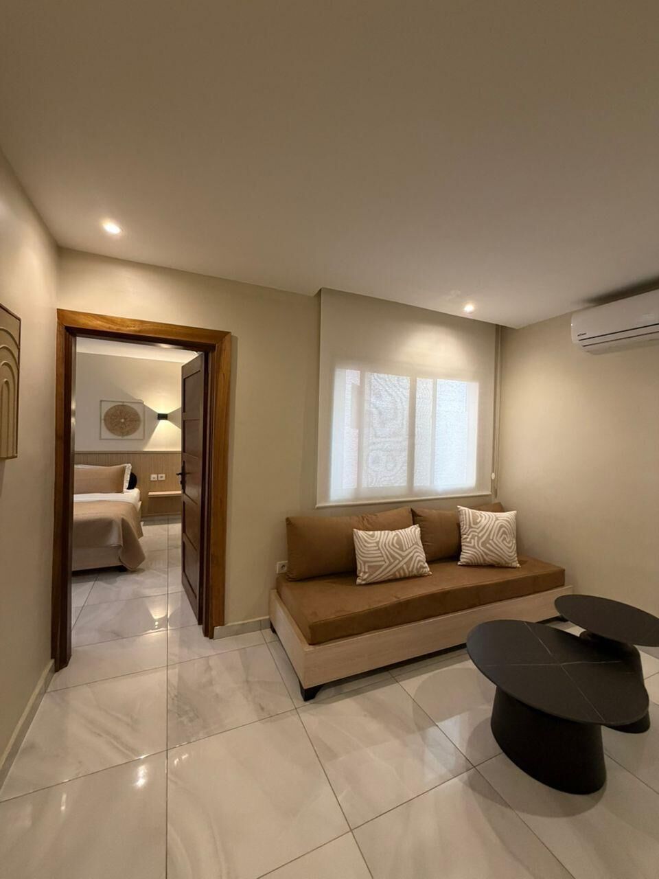 A modern living room with a sofa, a coffee table, and a dining table.