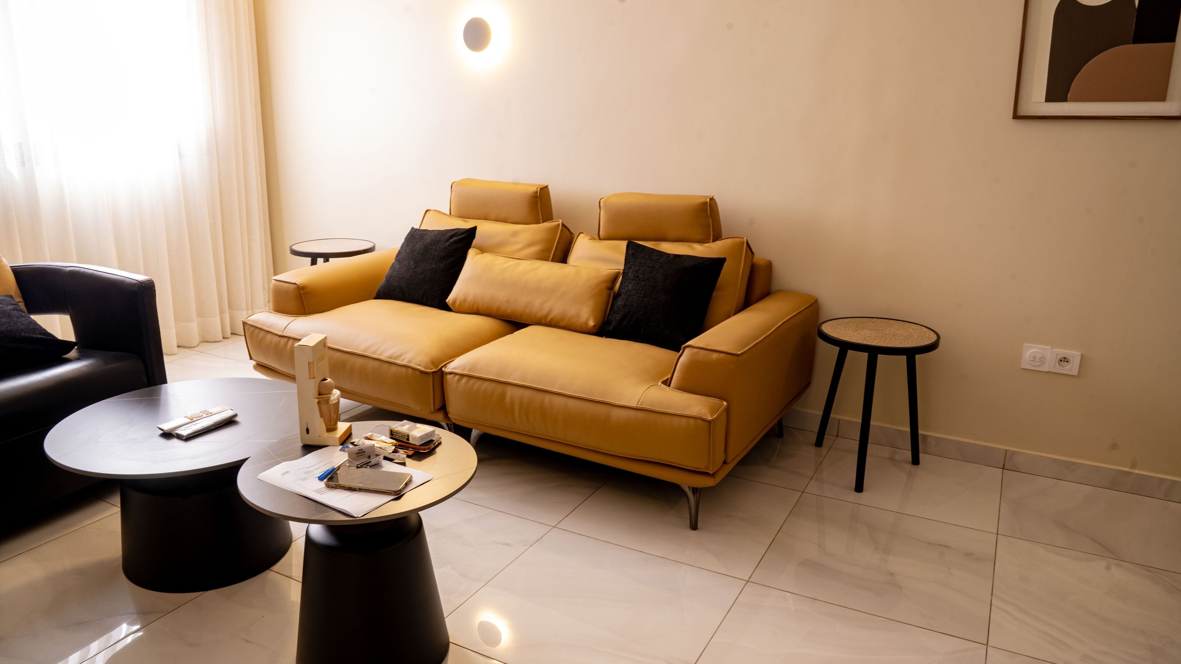 Una sala de estar moderna con sofá, mesa de centro y una mesita auxiliar.