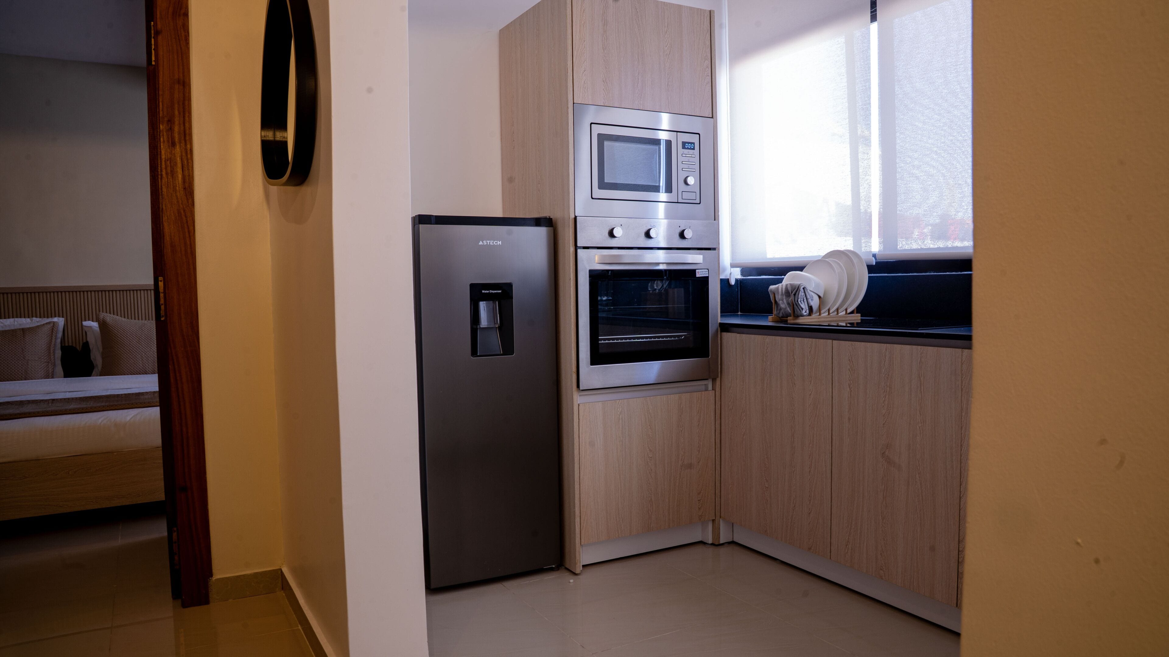 A compact kitchen with a refrigerator, oven, and microwave.