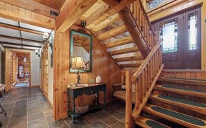 A wooden interior with a staircase, a mirror, a lamp, and a fireplace. - Gorgeous 4-bedroom Log Lodge in the pines. Custer, SD (Custer)