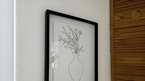 A framed black and white line drawing of a vase with flowers on a white wall. - Stylish Flat Near Whitechapel - Pass the Keys (London)