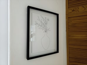 A framed black and white line drawing of a vase with flowers on a white wall. - Stylish Flat Near Whitechapel - Pass the Keys (London)