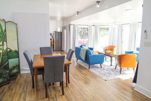 A modern living room with a dining area, a sofa, and a coffee table.