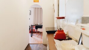 Una cocina con una licuadora, un lavamanos y un ventanal.