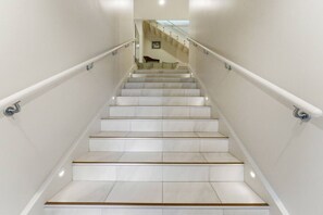 A staircase with white walls and a handrail. - Spacious 4BR Birkenhead Retreat | 3 Living Areas (Auckland North Shore)