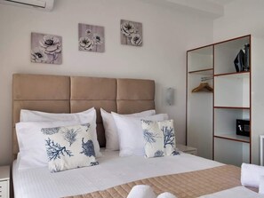 A hotel room with a bed, a wardrobe, and wall art. - Central sunset view #2 (Himarë)