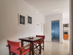 A dining area with a wooden table and chairs, a small bowl, and two framed artworks on the wall. - Central sunset view #1 (Himarë)