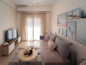 Una sala de estar moderna con un sofá, televisor y obras de arte en la pared.