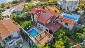 A multi-story house with a swimming pool, surrounded by greenery and a view of the sea. - Ionian Manor Estate villa (Porto Palermo)