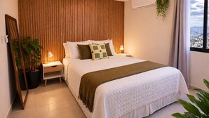 Un dormitorio moderno con una cama, mesitas de noche, una planta en maceta y vistas a través de una ventana.